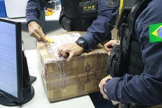 Policiais abrem encomenda com produto ilícito (Foto: divulgação/Correios) 