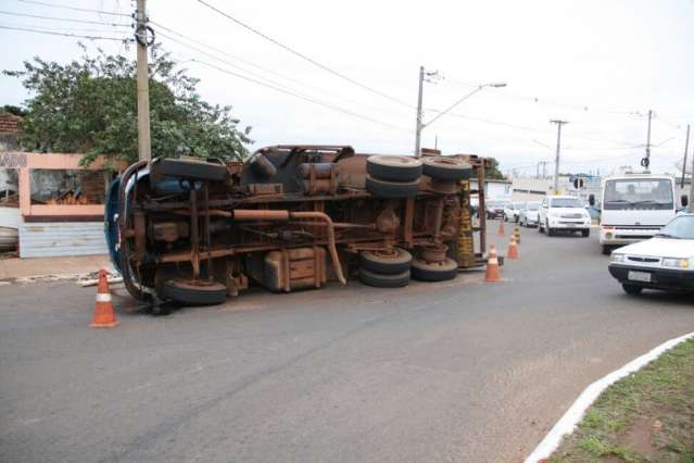 Carregado com tr&ecirc;s ca&ccedil;ambas e entulho, caminh&atilde;o tomba em rotat&oacute;ria