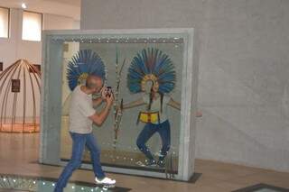 O casal tirando foto no cocar indígena (Foto: Alana Portela)