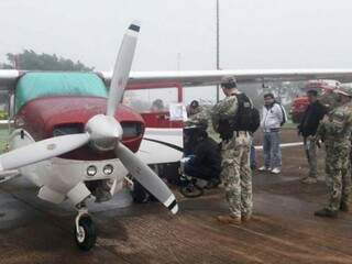 Avião de traficantes, apreendido em Pedro Juan; ao fundo, de casaco branco, o piloto brasileiro Paulo Tavares (Foto: ABC Color)