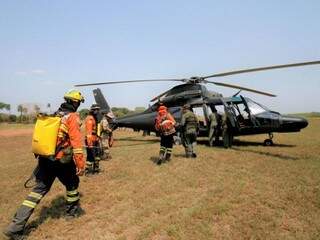 Equipes embarcando em helicóptero para mais auxiliar no combate aos incêndios na região do Pantanal (Foto: Saul Schramm/Governo do Estado)