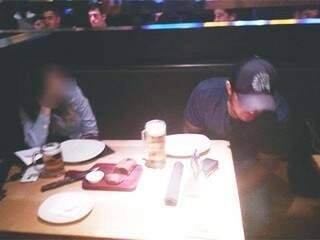 Foto tirada por amigos de segurança mostram acusado em restaurante, com cerveja à mostra (Foto: Direto das Ruas)