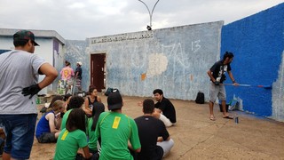 Os alunos sentados vendo pintar o muro da escola (Foto: Arquivo pessoal)
