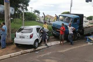 Caminhão “fura” sinal, colide com Celta e motorista fica presa às ferragens
