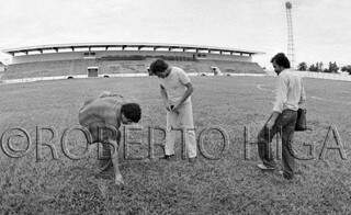 Da esquerda para a direita, jornalista Silvio Andrade, fotografo Walmirar Gomes e jornalista Oscar Ramos Gaspar vistoriam gramado na reinauguração do Estádio Arthur Marinho, em Corumbá (Foto: Roberto Higa)