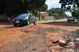 Carros que trafegam pela rua precisam passar por buracos  (Fotos: João Garrigó)
