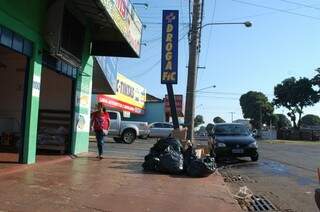 Em frente à peixaria, sacos de lixo não foram levados. (Foto: Simão Nogueira)