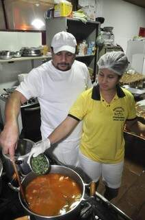 Casal preparando juntos a famosa Mojica. (Foto: João Garrigó)