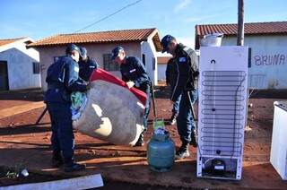 Policiais militares ajudam famílias a fazer mudança de casas invadidas em abril (Foto: Eliel Oliveira)