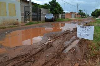 No Conjunto União os moradores os bairro criticaram a falta de asfalto com uma placa ao lado do buraco (Foto: Simão Nogueira)