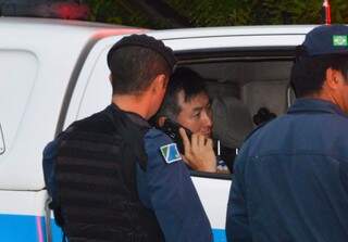 Policial falando ao celular no dia em que matou o empresário com cinco tiros (Foto: Simão Nogueira)