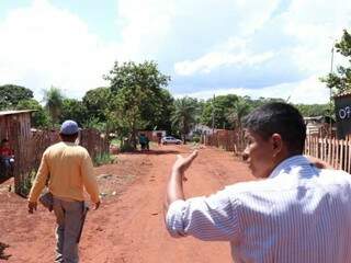 Moradores mostrando o terreno que será afetado com a abertura de duas ruas. (Foto: Henrique Kawaminami)