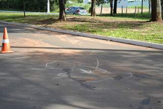 Marcação no asfalto mostra ponto onde a moto parou - após bater em meio-fio e árvore- e manchas de sangue. (Foto: Nadyenka Castro)