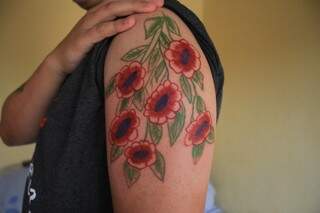 Desenho das flores foi eternizado no braço de Jhully. (Foto: Marina Pacheco)