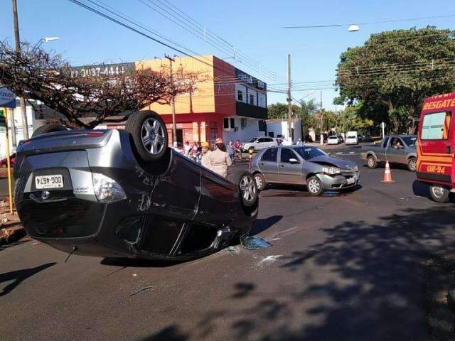 Colis&atilde;o em cruzamento de avenida em obras deixa carro de rodas para cima