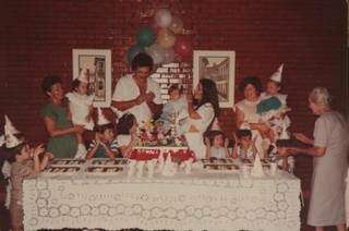 Na casa da avó, a parede de tijolinho ganhava decoração e balões. E na mesa, até copo fazia parte do embelezamento. (Foto: Arquivo Pessoal)