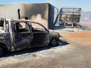 Caminhonete queimada por guerrilheiros; ao fundo, barracão e carreta também queimados (Foto: Mbykymi Notícias)