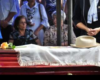 Lúdio foi enterrado com bandeira da imagem de Nossa Senhora e chapéu que sempre usava. Sua esposa, Nilda Coelho, presta última homenagem. (Foto: João Garrigó)