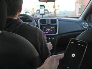 Aplicativo no celular e motorista que opera pela Uber (Foto: Marcos Ermínio)