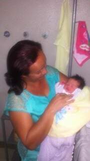 Maria Geralda traz ao colo sua primeira neta, que nasceu dias após a morte do avô, vítima de infarto