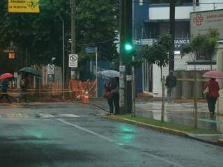 Na Capital, trabalhador saiu agasalhado e com guarda-chuva nesta quinta-feira (Foto: Henrique Kawaminami)