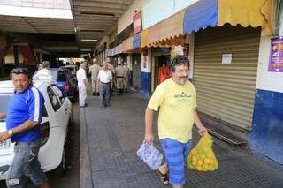 Comerciante, de amarelo, deixa loja após interdição (Foto: Gerson Walber)