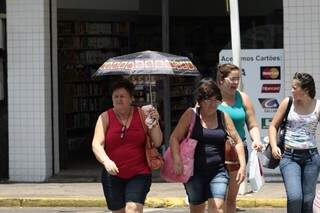 Para afastar o calor, o guarda-chuva se torna item obrigatório. 