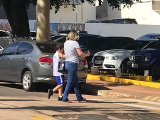 Mãe deixando a escola de mãos dadas com o filho antes do término das aulas (Foto: Ronie Cruz)