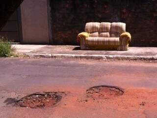 Sofá e buracos são encontrados em rua do bairro Vila Rica. (Foto: Direto das Ruas)