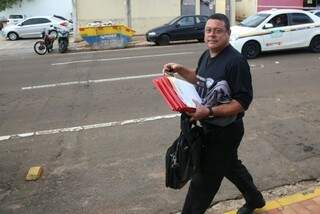 Agente do Gaeco deixa delegacia com documentos e malote. (Foto: Fernando Antunes).