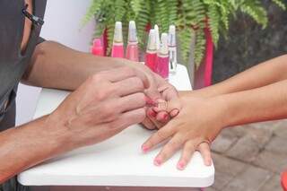 Lyz oferece algumas opções de esmaltes rosas para os participantes pintarem as unhas (Foto: Paulo Francis)