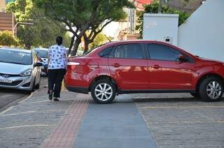 Piso tátil fica inutilizável com quando veículos estacionam no estabelecimento na José Antonio  (Foto: Vanderlei Aparecido)
