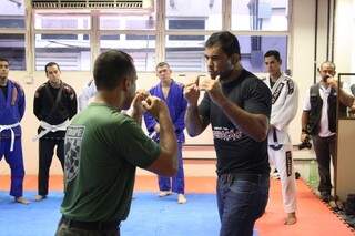 Durante instrução de técnica, lutador chama policial para demonstrar golpe. 