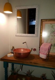 O banheiro com torneira de cano e pia de tacho, formas inteligentes de tornar o ambiente único e também economizar.