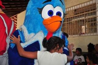 Criança do abrigo abraça uma das personagens mais famosas do musical. (Foto: João Garrigó)