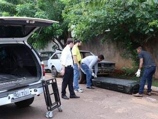 Agentes da funerária recolhem corpo de homem encontrado em calçada de escola (Foto: Henrique Kawaminami) 