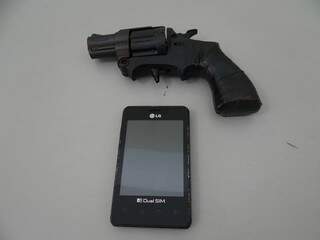 Arma de brinquedo utilizada pelo ladrão e celular roubado da loja. (Foto: Osvaldo Duarte)
