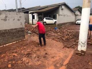 Depois da chuva, moradores tentam limpar área do residencial (Foto: Fernanda Palheta)