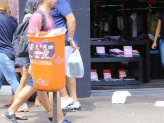 Sacola de plástico jogada no chão, a alguns metros de uma lixeira, instalada na Rua 14 de Julho. (Foto: André Bittar)