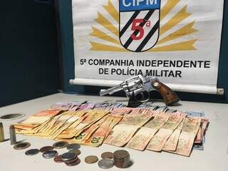 Arma apreendida com o ladrão e o dinheiro recuperado: suspeito de mais ações semelhantes na cidade (Foto: Divulgação/PM)