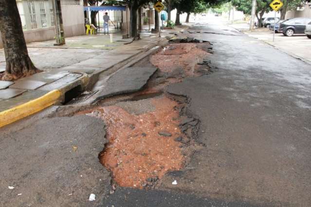 Enxurrada forte alaga bar, casas e arranca asfalto de ruas e avenidas