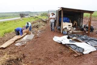 Sem-terra enrolam rola de barraco desmontado durante reintegração de fazenda arrendada por usina de Bumlai (Foto: Eliel Oliveira)