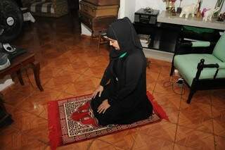 No tapete e usando o hijab, ela faz suas orações diárias, aprendidas com o Alcorão. (Foto: Paulo Francis)