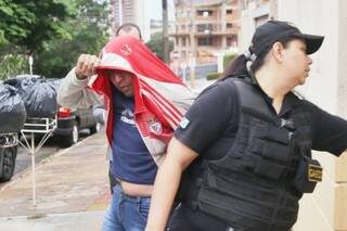 Preso em operação sendo escoltado por agente do Gaeco na frente da Corregedoria da PM (Foto: Fernando Antunes)