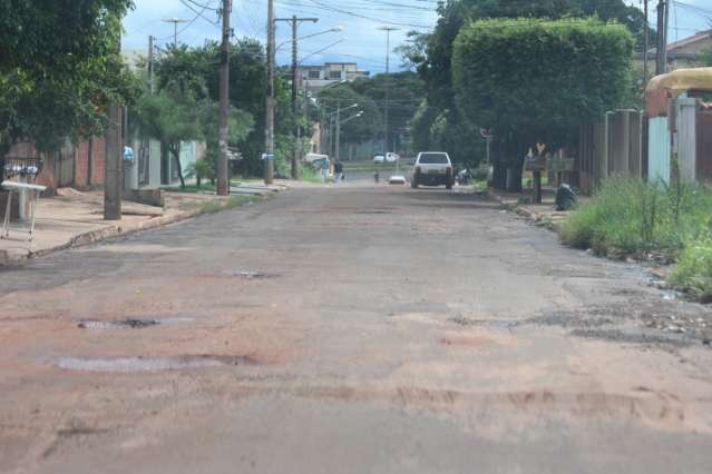 Cansados de esperar, moradores improvisam opera&ccedil;&atilde;o tapa-buraco