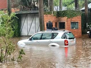 Motorista subiu no teto do carro para fugir da inundação (Foto: ABC Color)
