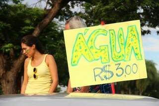 A veterinária Bruna Bastos e seu tio aproveitaram movimento para vender água. (Foto:Fernando Antunes) 