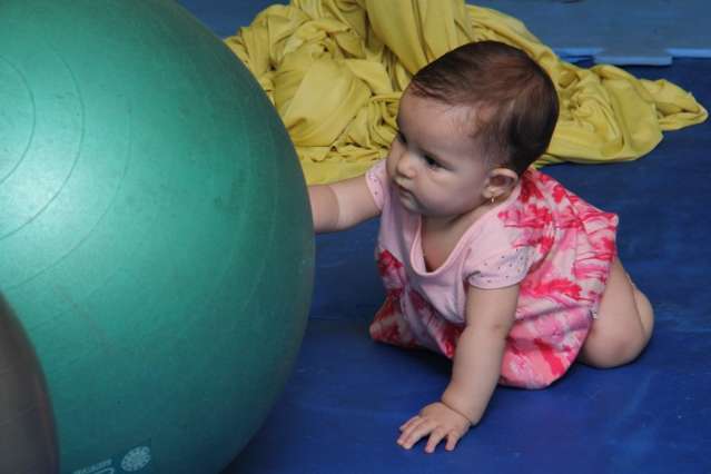 M&atilde;es fazem exerc&iacute;cios enquando os beb&ecirc;s se divertem em aula de Pilates