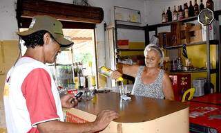 Ana servindo um cliente no bar Nova Alvorada, onde está há 30 anos. (foto: Roberto Higa)