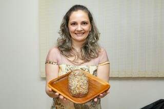 Drika com o Pão com castanhas e sementes nas mãos (Foto: Kisie Ainoã)